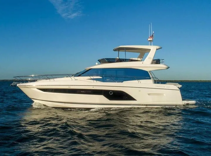  Yacht Photos Pics Luxury 2022 Prestige 590 yacht cruising on open water under clear blue sky.
