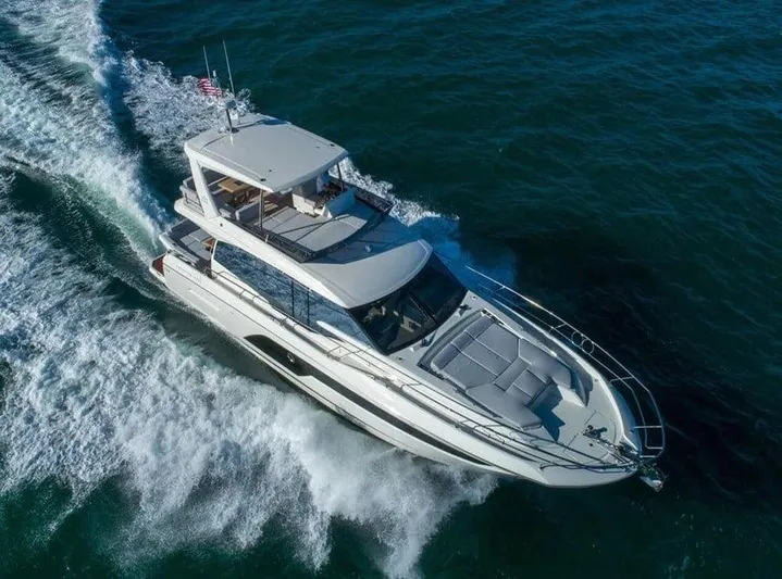  Yacht Photos Pics 2022 Prestige 590 yacht cruising on open water, aerial view.