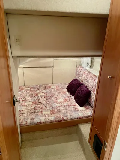 Casting Shadows Yacht Photos Pics 1998 Bayliner 3988 Command Bridge Motoryacht cabin with patterned bedding and purple pillows.