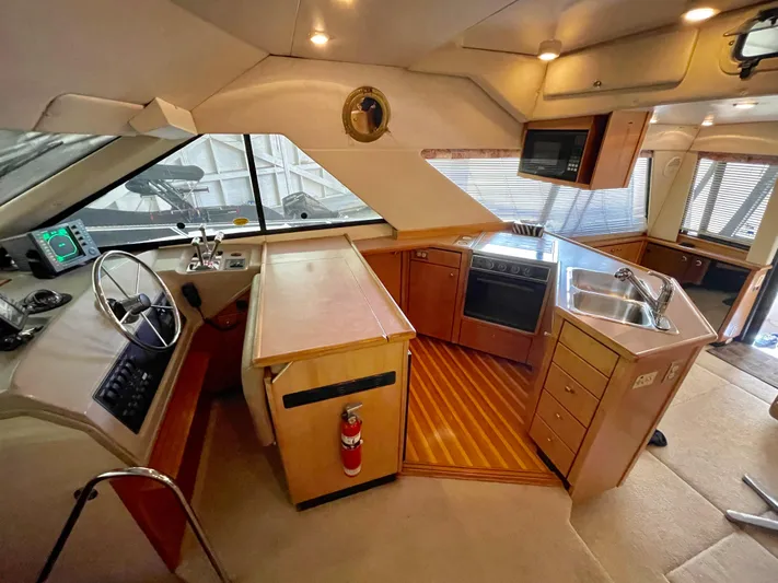 Casting Shadows Yacht Photos Pics 1998 Bayliner 3988 Command Bridge Motoryacht interior with helm, kitchen, and dining area.
