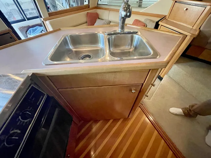 Casting Shadows Yacht Photos Pics 1998 Bayliner 3988 Command Bridge Motoryacht kitchen with dual sink and wooden cabinetry.