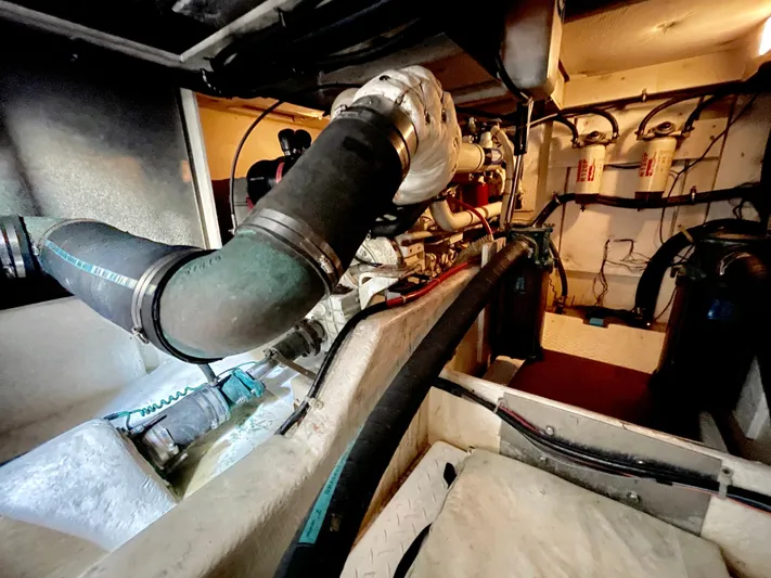 Casting Shadows Yacht Photos Pics Engine room of 1998 Bayliner 3988 Command Bridge Motoryacht, showcasing mechanical components and piping.