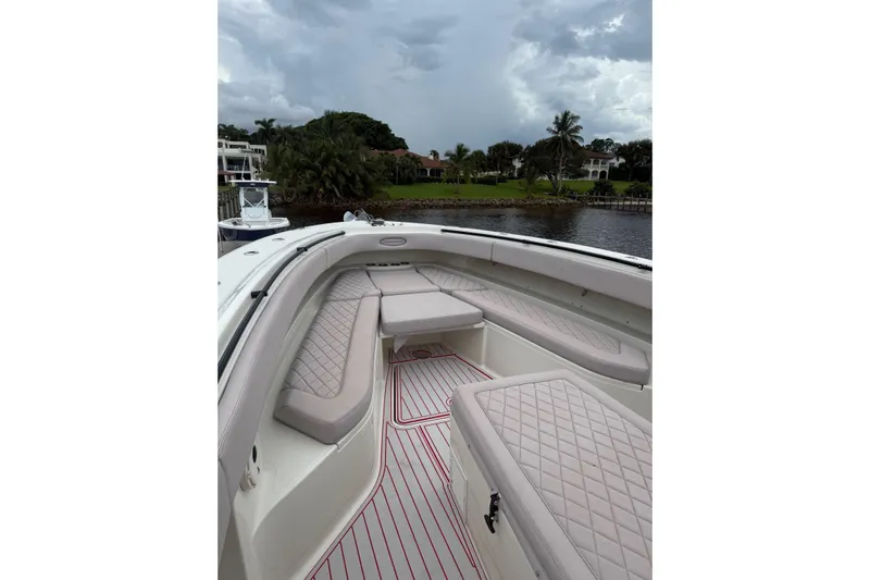 42 - Brokerage Higgins Yacht Photos Pics 2013 Hydra-Sports 42 boat interior with cushioned seating, docked by a scenic waterfront.