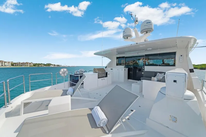 Valiant Yacht Photos Pics Luxurious Horizon E81 yacht deck with lounge chairs, ocean view, and clear blue sky, 2022 model.