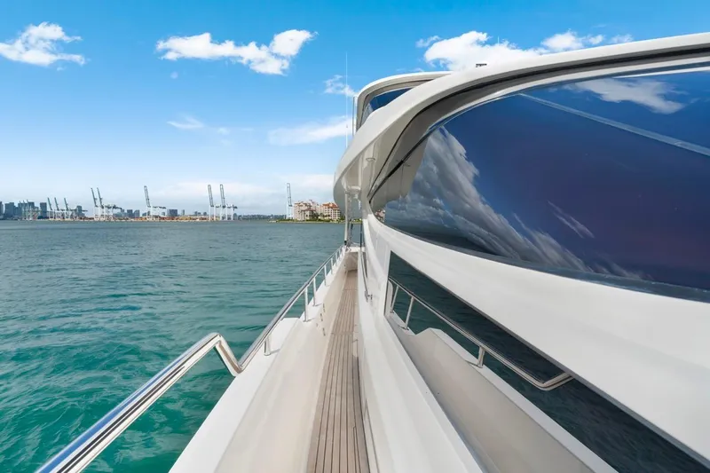 Valiant Yacht Photos Pics 2022 Horizon E81 yacht cruising near a city skyline under a clear blue sky.