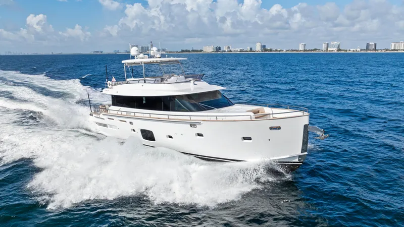  Yacht Photos Pics 2016 Azimut Magellano 76 yacht cruising on open sea with city skyline in background.