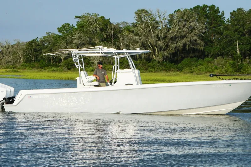  Yacht Photos Pics 2022 Contender 35 ST boat cruising on a calm river with lush green trees.