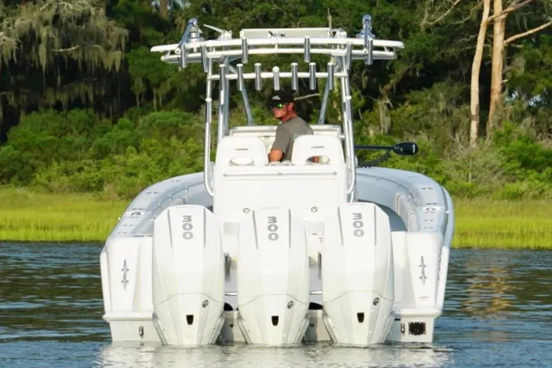  Yacht Photos Pics 2022 Contender 35 ST boat with triple 300 horsepower engines on a calm waterway.