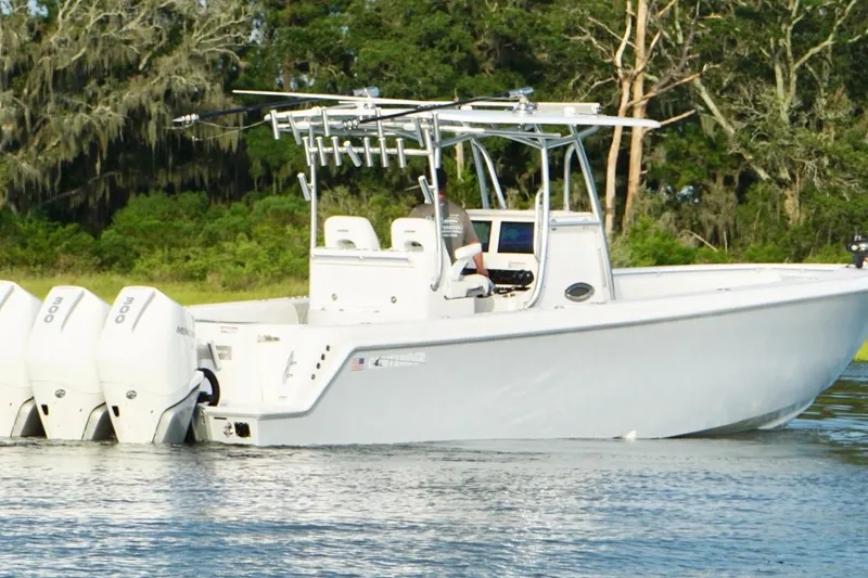  Yacht Photos Pics 2022 Contender 35 ST boat with triple outboard engines on a calm waterway.