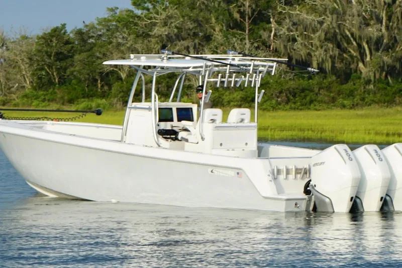  Yacht Photos Pics 2022 Contender 35 ST boat with triple outboard engines on a calm waterway.