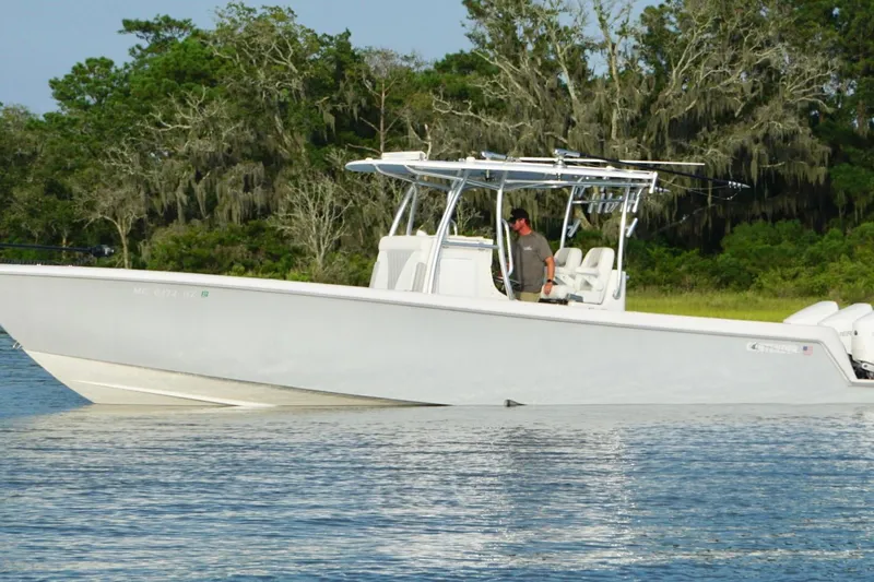  Yacht Photos Pics 2022 Contender 35 ST boat on calm water, surrounded by lush greenery.