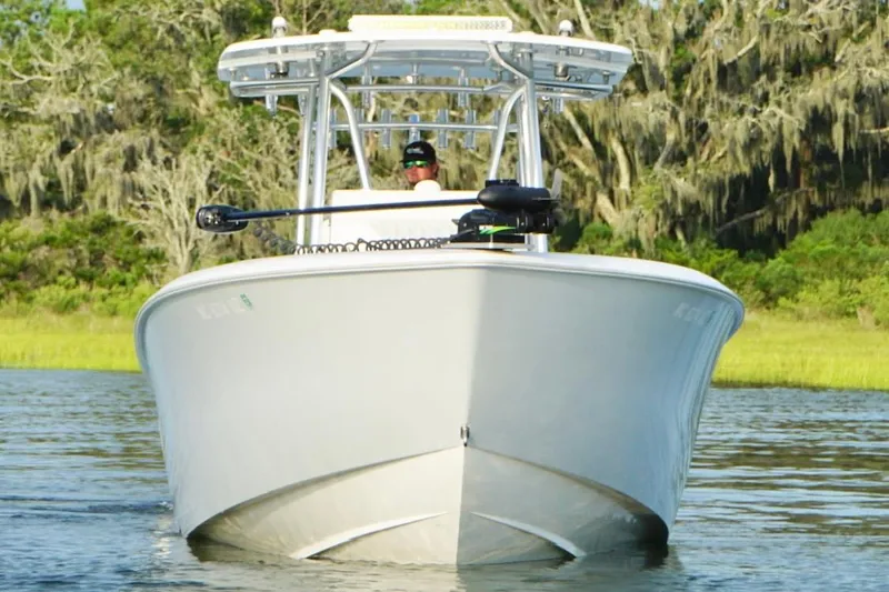  Yacht Photos Pics 2022 Contender 35 ST boat cruising on a calm river with lush greenery.