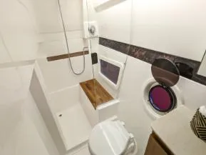 Custom Order Your 375 Today! Yacht Photos Pics 2025 Hanover 375 Outboard boat bathroom with modern fixtures and porthole window.