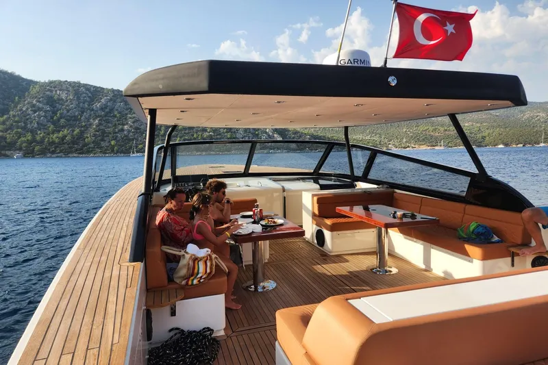  Yacht Photos Pics Luxury yacht Phantom Spook 62, 2025 model, with people dining, Turkish flag, scenic coastal view.