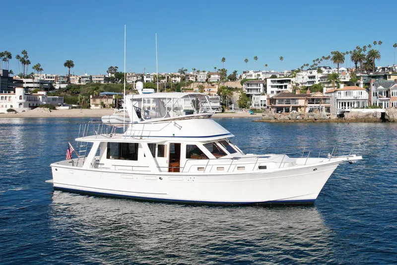 Treasure Yacht Photos Pics 1997 Offshore Yachts 48 Sedan cruising near coastal homes.