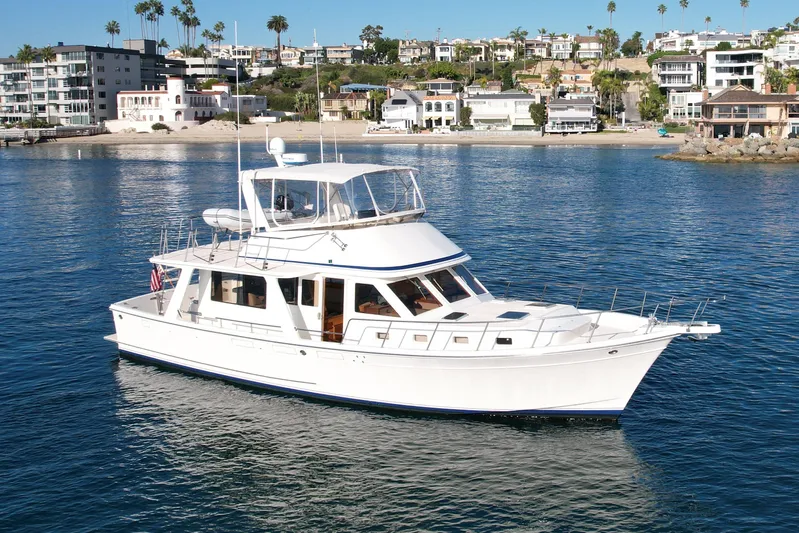 Treasure Yacht Photos Pics 1997 Offshore Yachts 48 Sedan cruising near coastal homes.