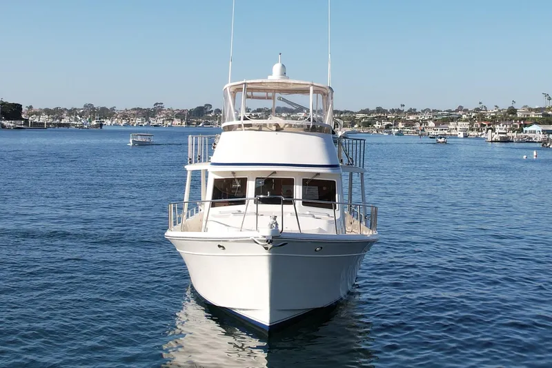 Treasure Yacht Photos Pics 1997 Offshore Yachts 48 Sedan on calm water, clear sky, coastal background.