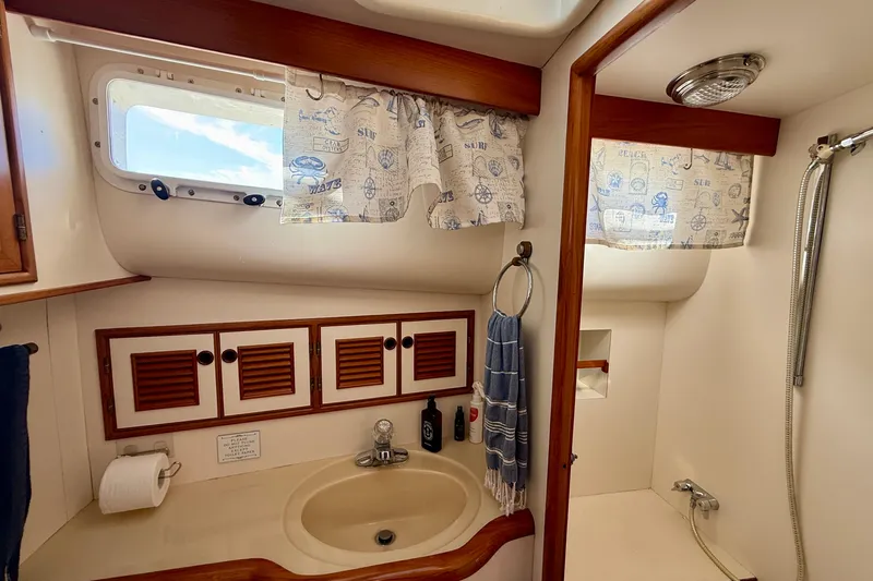 Treasure Yacht Photos Pics Bathroom interior of 1997 Offshore Yachts 48 Sedan with sink, shower, and nautical decor.