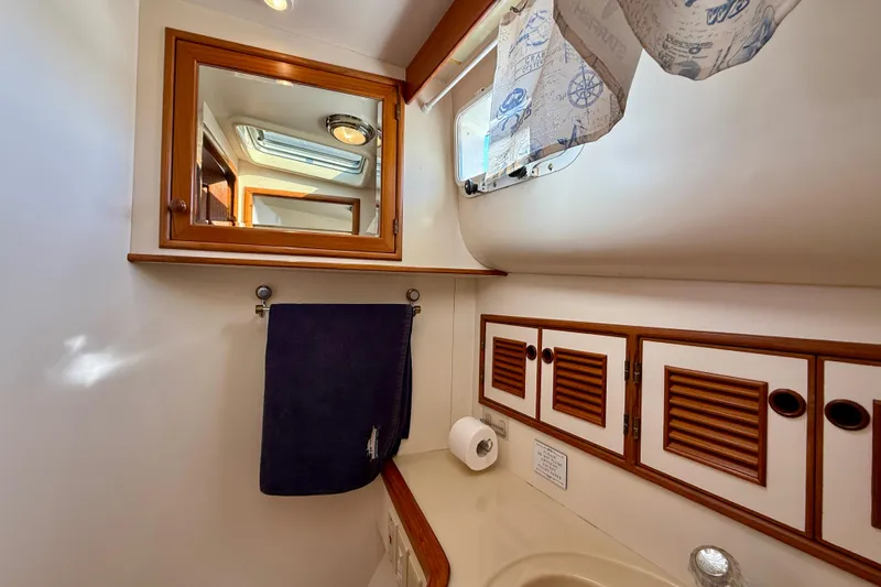 Treasure Yacht Photos Pics Bathroom interior of 1997 Offshore Yachts 48 Sedan with mirror, towel, and cabinets.