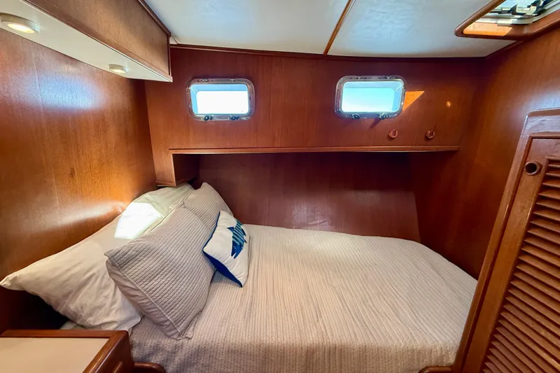 Treasure Yacht Photos Pics Cozy cabin interior of 1997 Offshore Yachts 48 Sedan with wooden finish and porthole windows.