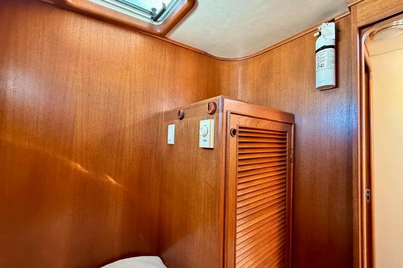 Treasure Yacht Photos Pics Wood-paneled interior of 1997 Offshore Yachts 48 Sedan with fire extinguisher and vented cabinet.
