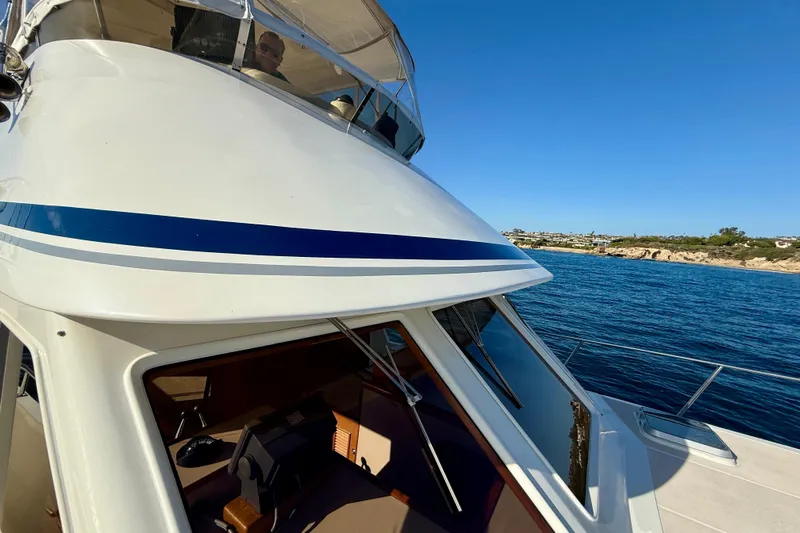 Treasure Yacht Photos Pics 1997 Offshore Yachts 48 Sedan cruising on clear blue waters under a sunny sky.