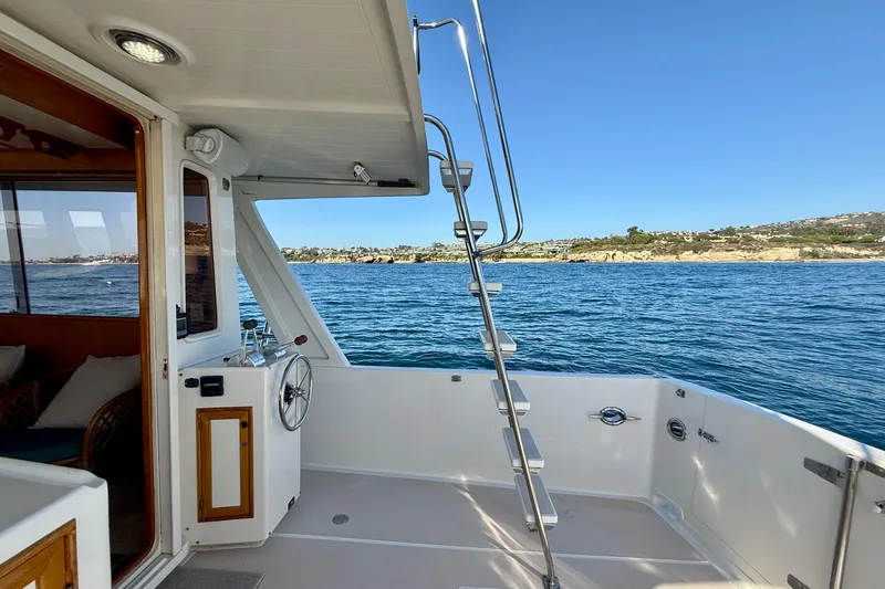 Treasure Yacht Photos Pics 1997 Offshore Yachts 48 Sedan, deck view with ocean and coastal landscape.