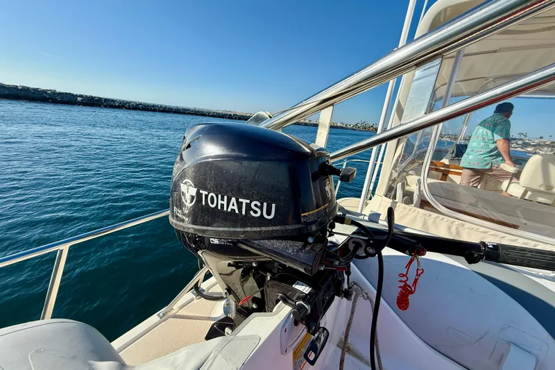 Treasure Yacht Photos Pics 1997 Offshore Yachts 48 Sedan with Tohatsu outboard motor on a sunny day at sea.