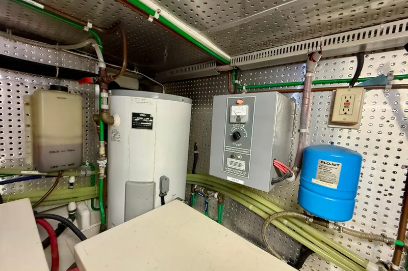 Treasure Yacht Photos Pics Engine room of 1997 Offshore Yachts 48 Sedan with water heater and battery charger.