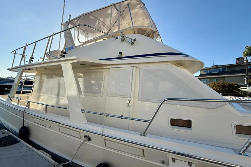 Treasure Yacht Photos Pics 1997 Offshore Yachts 48 Sedan, docked, showcasing sleek design and upper deck.