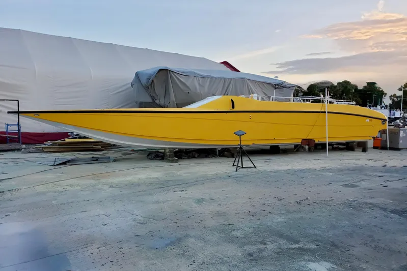 Yacht Photos Pics Yellow 2005 Thriller Powerboats Super Cat 55 on dry dock at sunset.