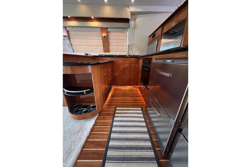 Our Trade Yacht Photos Pics Luxurious 2006 Carver 56 Voyager yacht kitchen with wood cabinetry and stainless steel appliances.