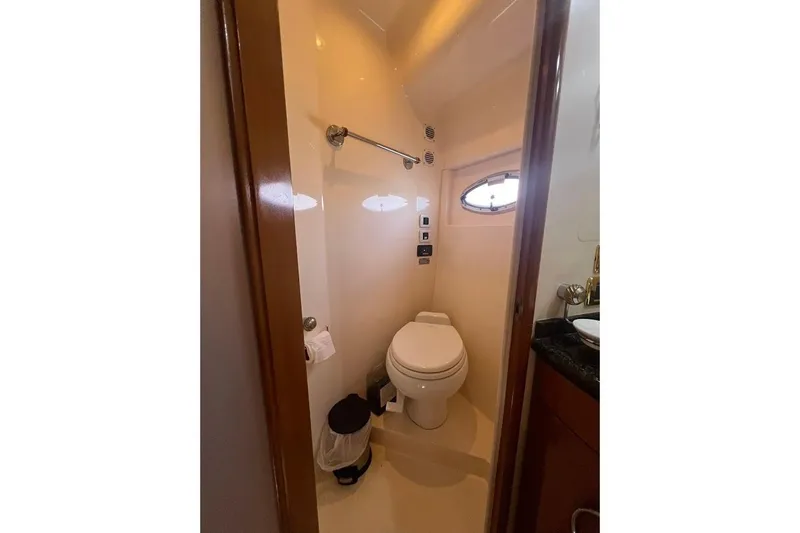 Our Trade Yacht Photos Pics Bathroom interior of 2006 Carver 56 Voyager yacht, featuring toilet and porthole window.