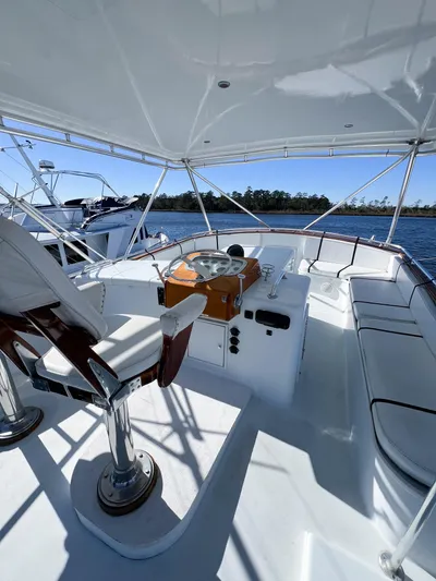 Lb. Cake Yacht Photos Pics 1987 Buddy Davis 61 Convertible yacht helm with seating, under canopy, on calm water.