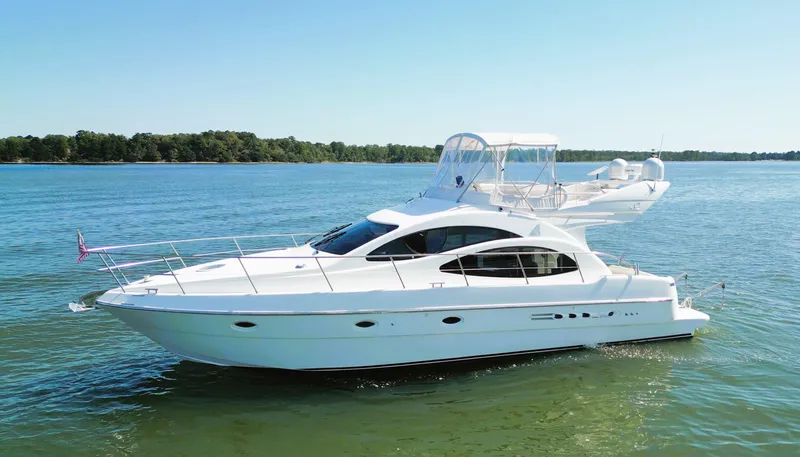 Four Shore Yacht Photos Pics 2002 Azimut 42 yacht cruising on a serene lake under clear blue skies.