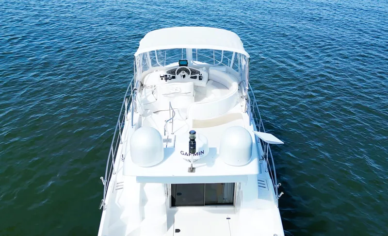 Four Shore Yacht Photos Pics Azimut 42 yacht from 2002 on calm blue water, aerial view.