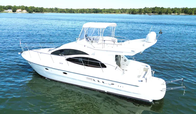 Four Shore Yacht Photos Pics 2002 Azimut 42 yacht cruising on a serene lake under clear skies.