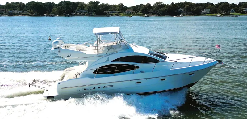 Four Shore Yacht Photos Pics Azimut 42 yacht cruising on a sunny day, 2002 model, on a serene lake.