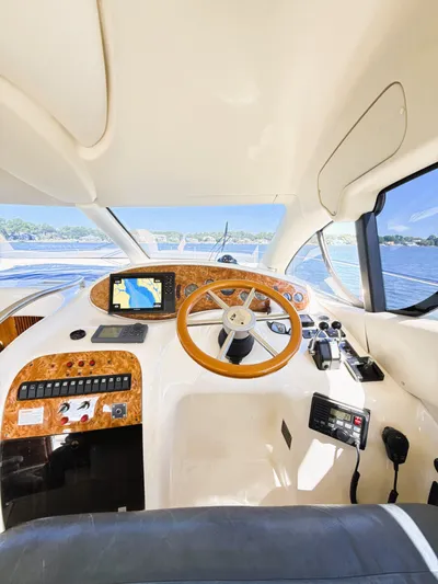 Four Shore Yacht Photos Pics Interior view of 2002 Azimut 42 yacht cockpit with wooden steering wheel and navigation system.