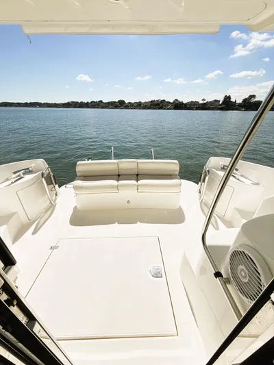 Four Shore Yacht Photos Pics 2002 Azimut 42 yacht deck with seating, overlooking serene water and clear sky.