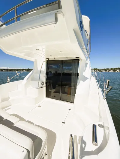 Four Shore Yacht Photos Pics 2002 Azimut 42 yacht, sleek white deck, glass doors, sunny day on the water.