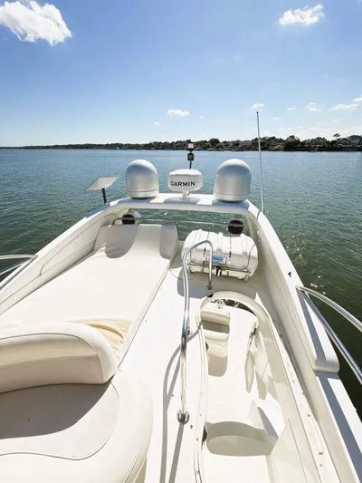 Four Shore Yacht Photos Pics 2002 Azimut 42 yacht with spacious deck, cruising on calm waters under a clear sky.