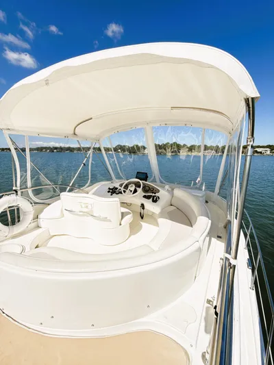 Four Shore Yacht Photos Pics 2002 Azimut 42 yacht helm with canopy on calm water under blue sky.