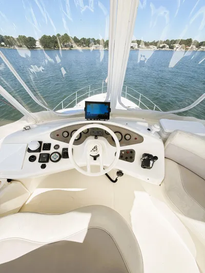 Four Shore Yacht Photos Pics 2002 Azimut 42 yacht helm with navigation controls, overlooking serene waters.