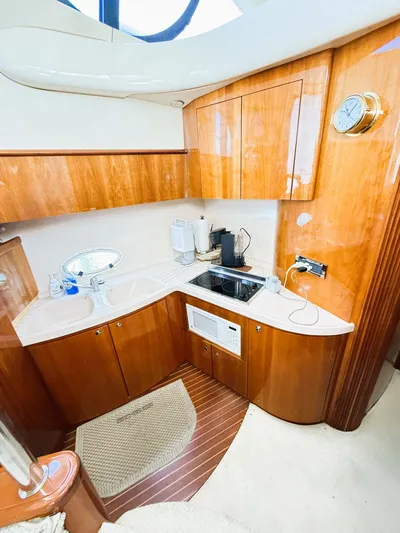 Four Shore Yacht Photos Pics Luxurious 2002 Azimut 42 yacht kitchen with wood cabinetry and modern appliances.