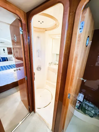 Four Shore Yacht Photos Pics Interior of 2002 Azimut 42 yacht showing bathroom and bedroom with wooden finishes.