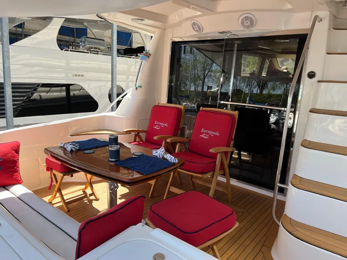Escapade Too Yacht Photos Pics 2007 Sea Ray 58 Sedan Bridge yacht with outdoor dining area and red cushioned seating.