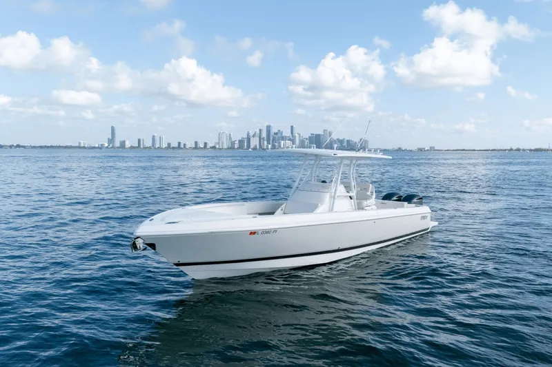  Yacht Photos Pics 2015 Intrepid 327 CC boat on calm water with city skyline in background.
