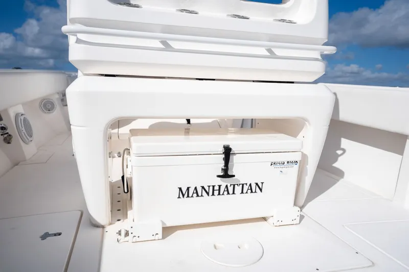  Yacht Photos Pics 2015 Intrepid 327 CC INFUSED boat with a "MANHATTAN" labeled cooler on deck.