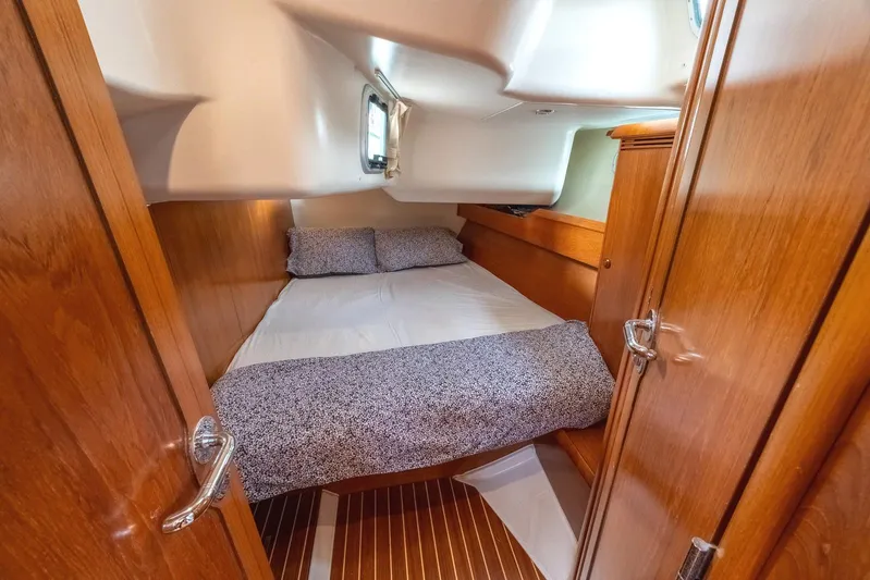  Yacht Photos Pics Cozy cabin interior of 2006 Jeanneau Sun Odyssey 49 sailboat with wooden finish.
